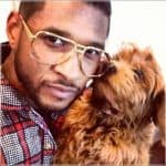 Usher singer with golden doddle dog